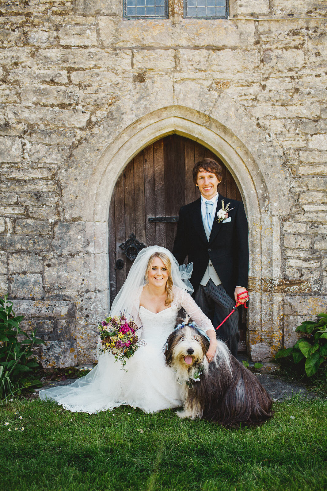 An image of Vikki as bride, Jimmy as groom, posing outside the church with the family’s bearded collie.