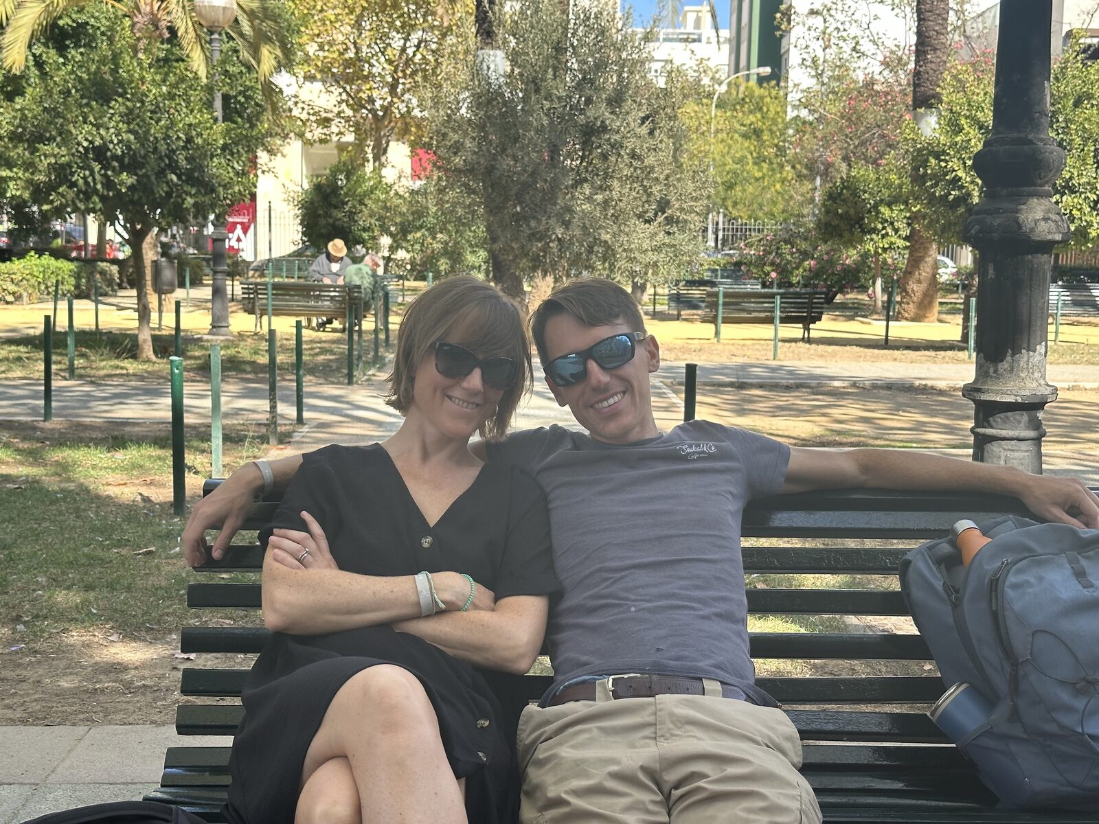 A photo of Vikki and Jimmy on a bench in a sunny garden in Cadiz, with their new haircuts